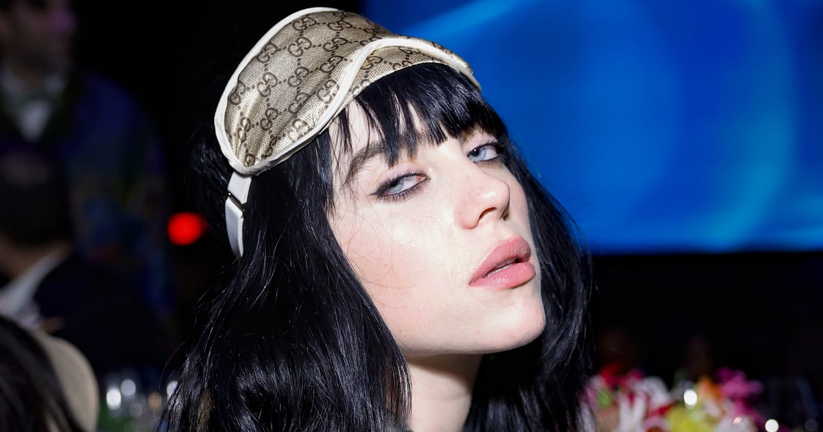 Billie Eilish porte des collants à logo Gucci avec une robe noire