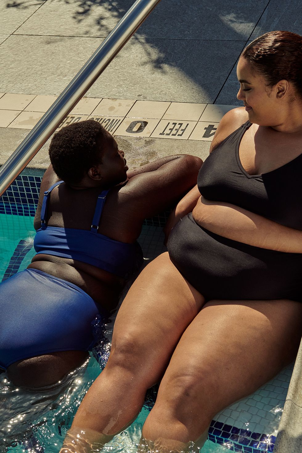 deux modèles dans une piscine portent des maillots de bain standard universels