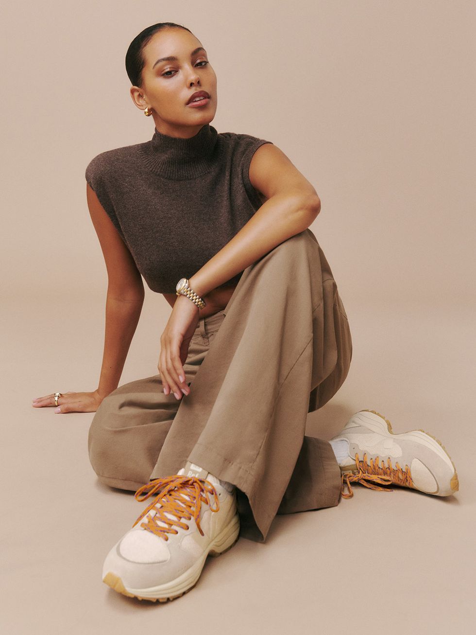 une femme assise par terre portant des baskets veja x reformation