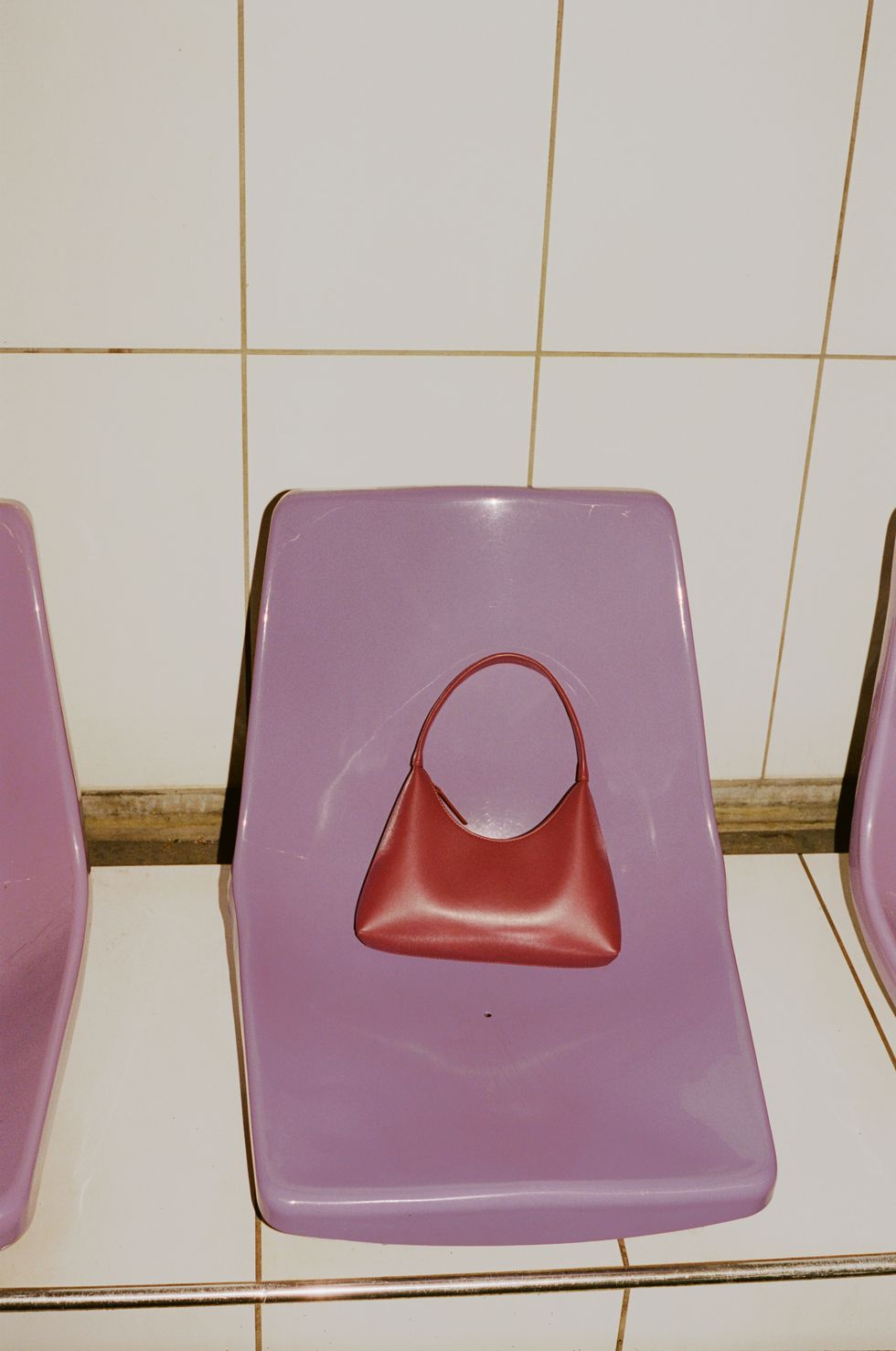 une chaise violette avec un sac rouge posé dessus