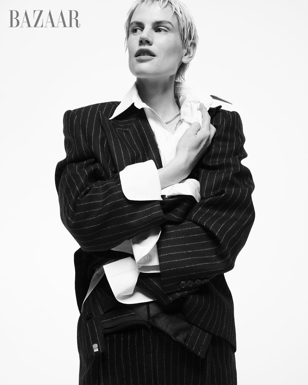 une femme portant une tenue noire et blanche et tenant une tasse blanche