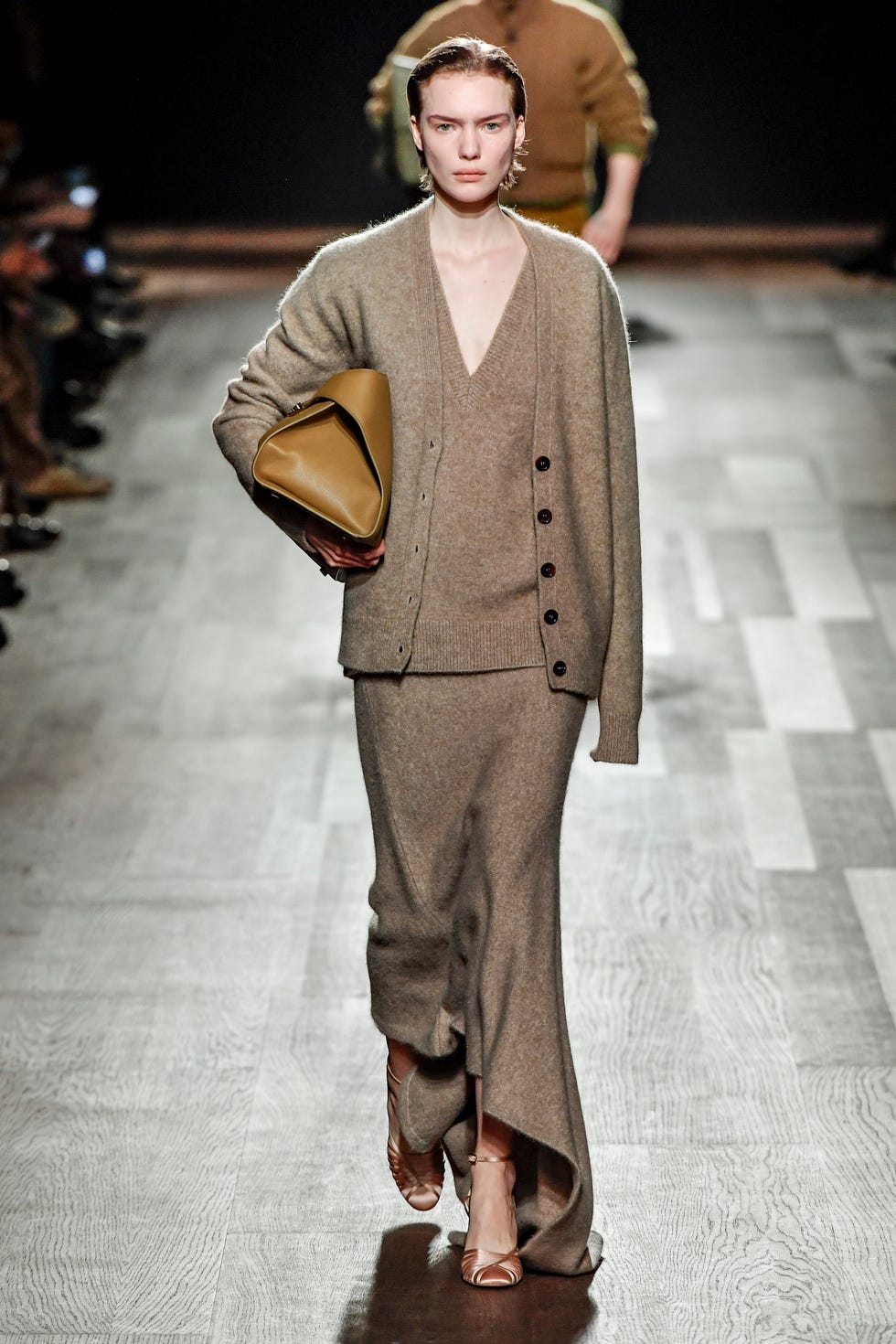 un mannequin portant un haut en tricot cardigan marron clair taupe et une jupe longue avec un sac en cuir camel sous le bras sur le défilé ferragamo rtw automne 2024 dans un tour d'horizon des meilleures tenues de cardigan 2024