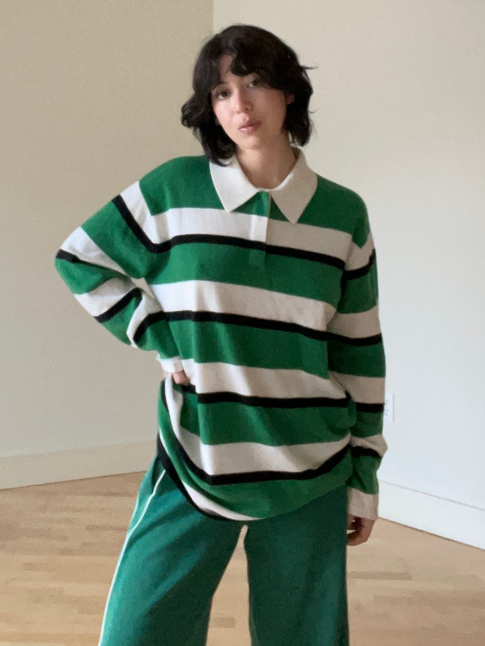 individu portant un pull rayé vert et blanc à rayures noires et un pantalon vert