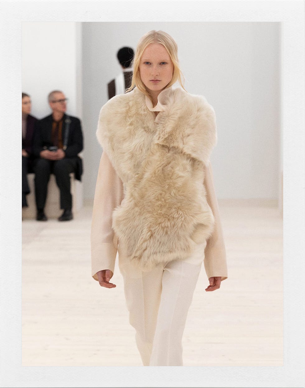 modèle portant un gilet en fourrure avec une palette de couleurs douces sur une piste