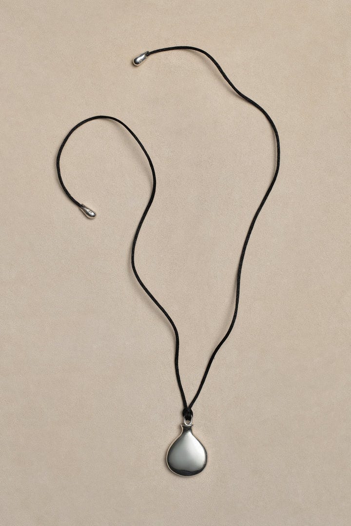 Un pendentif élégant en larmes sur un cordon noir