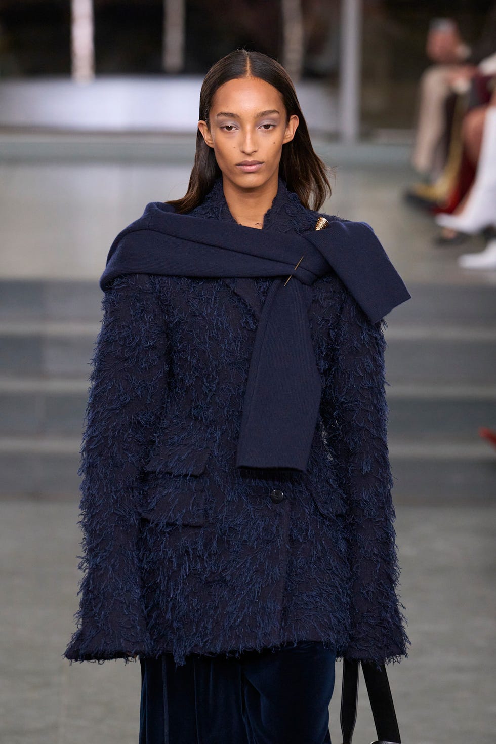 Modèle de mode présentant un manteau de marine texturé avec une écharpe