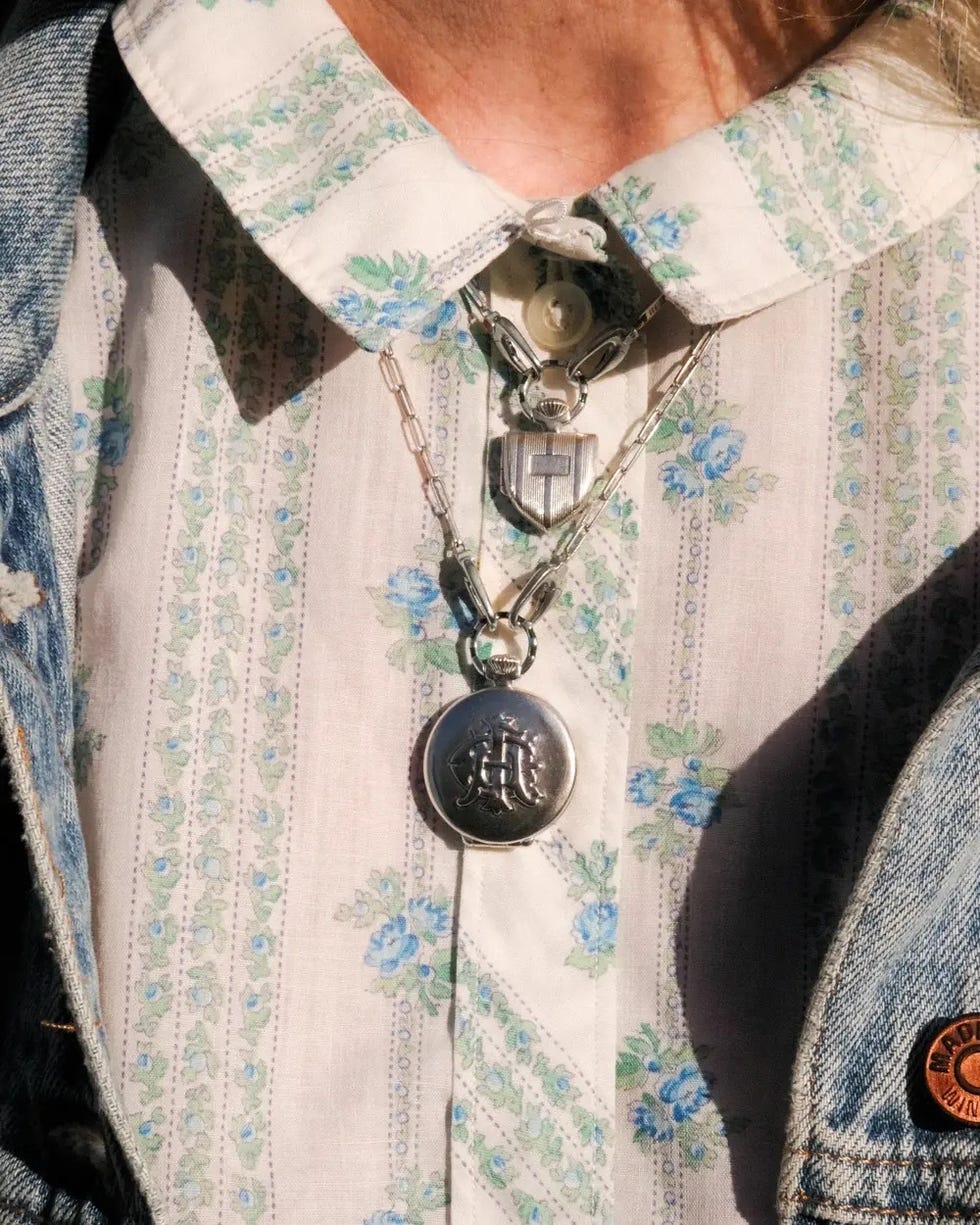 Closeup de colliers en couches portés sur une chemise boutonnée à fleurs