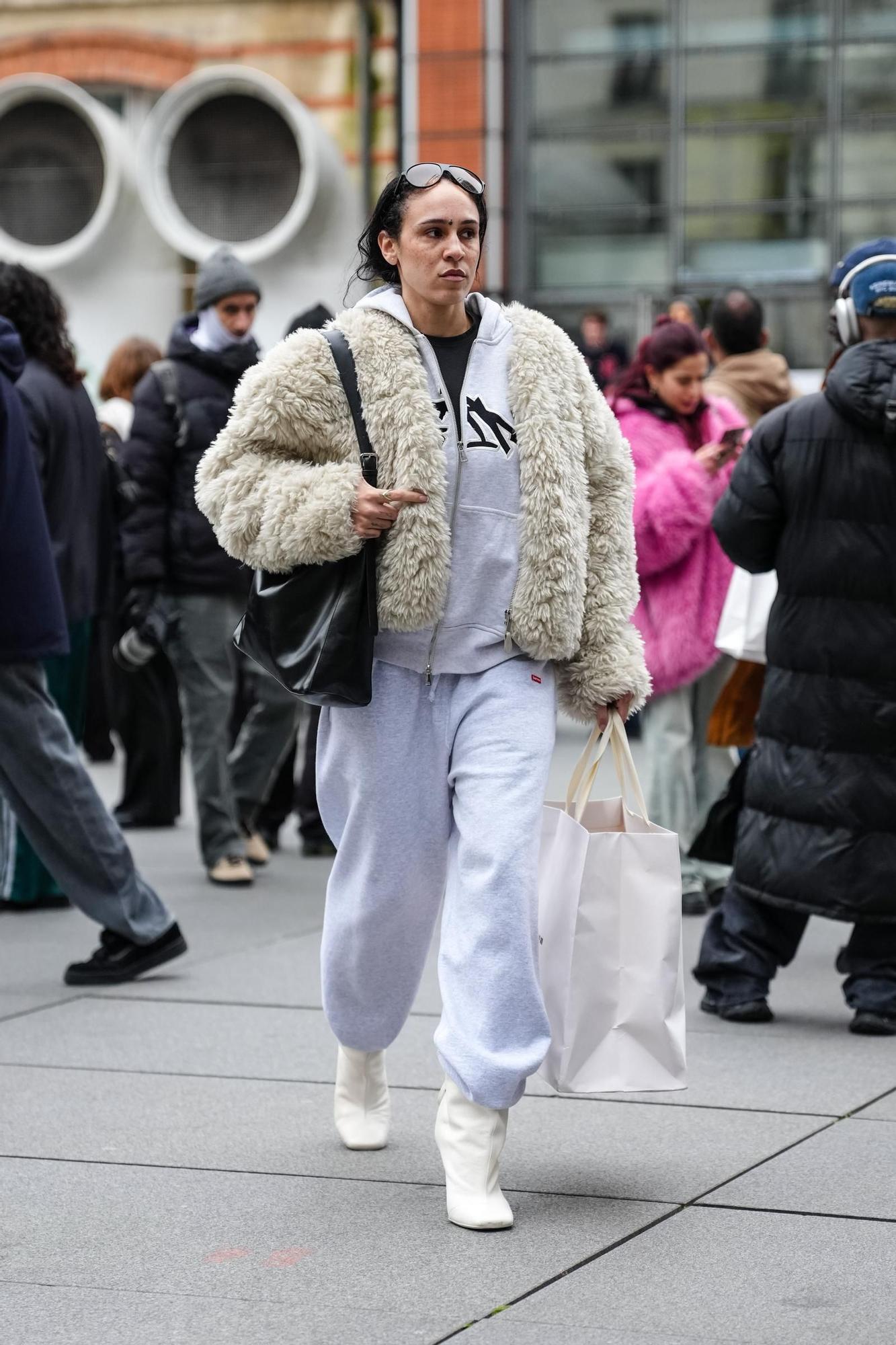 Une femme portant un survêtement avec des bottines à talons et une couche de cheveux