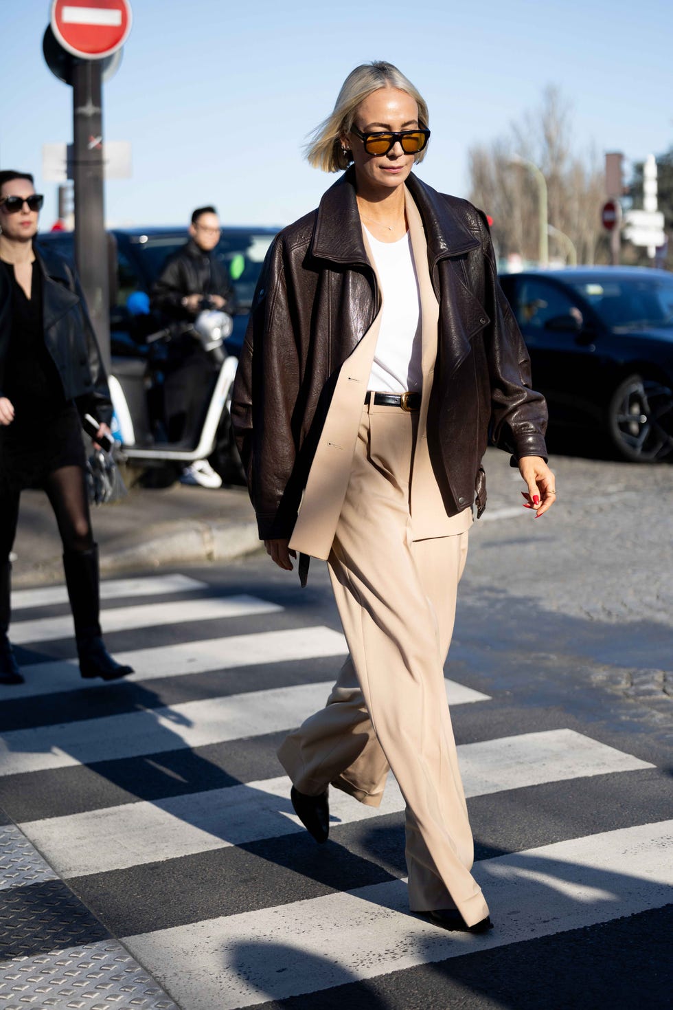 Une personne traversant la rue en tenue à la mode dégageant de confiance