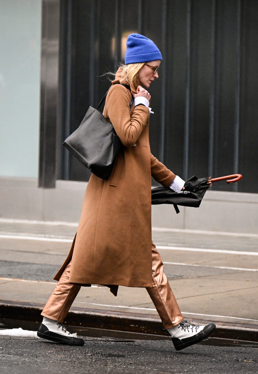 New York, New York 06 février: Un invité est vu portant un manteau brun, un sac noir, des bottes blanches et un bonnet bleu à l'extérieur du Brandon Maxwell Show pendant NYFW F / W 2025 le 06 février 2025 à New York. (Photo de Daniel Zuchnik / Getty Images)