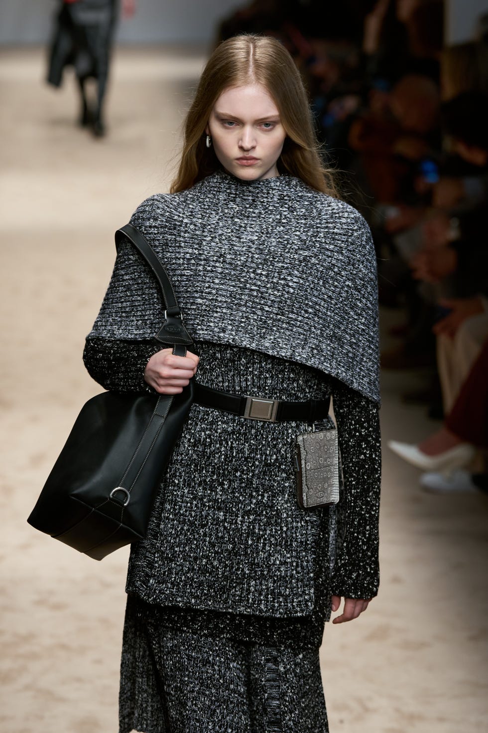 Modèle de mode présentant une tenue texturée avec des accessoires sur la piste