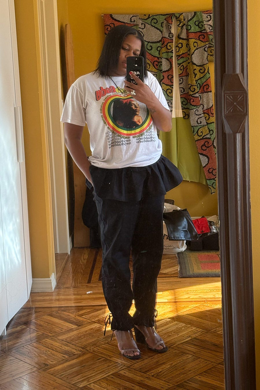 reflet miroir d'une personne portant un tshirt graphique et un pantalon élégant présentant une tenue décontractée