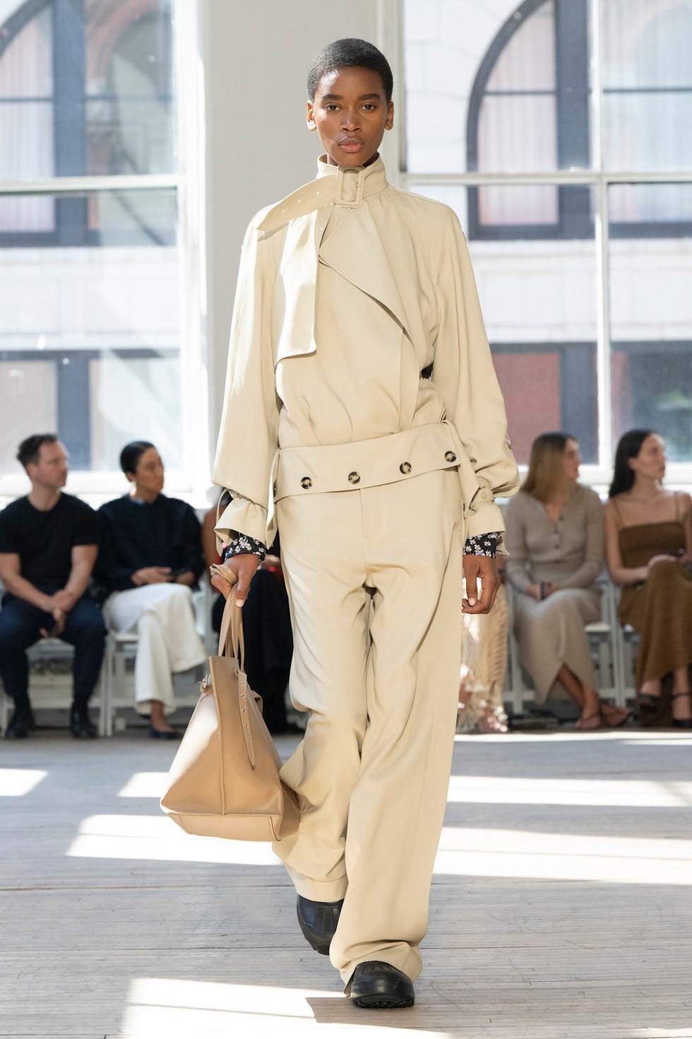 Modèle de piste présentant une tenue contemporaine avec un sac à main