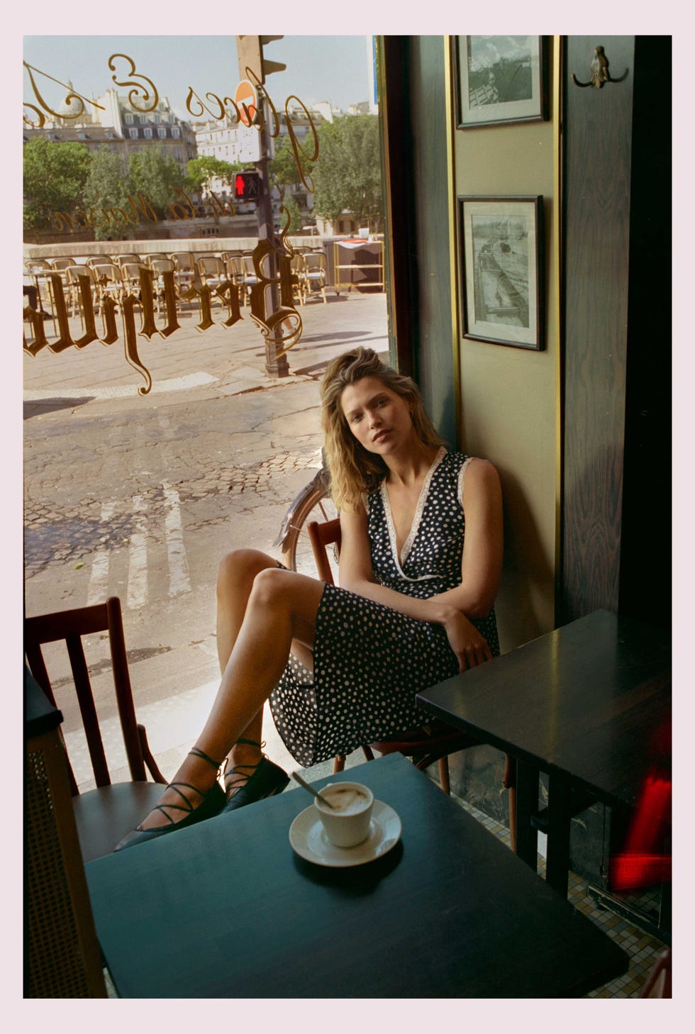 Une femme assise dans un café avec une tasse de café sur la table