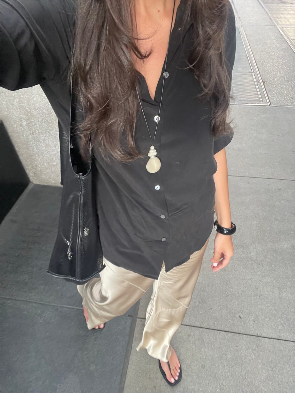 femme portant un pantalon de soie et une chemise boutonnée noire