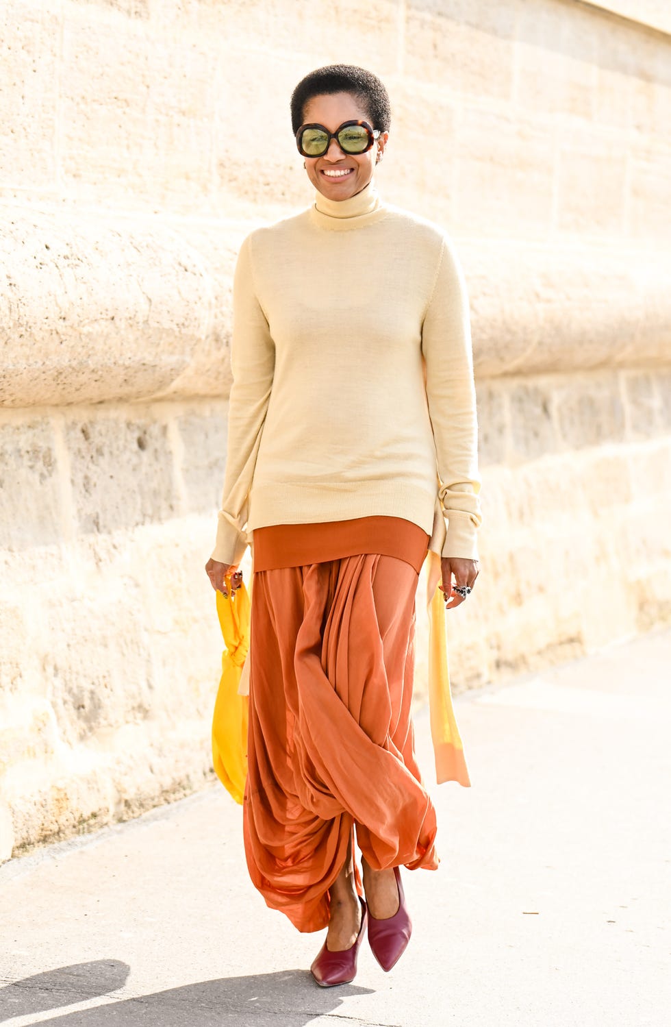 paris, france 01 octobre : tamu mcpherson porte un pull crème, une jupe orange, des talons marron et des lunettes à l'extérieur du défilé dior pendant le printemps-été 2026 de vêtements pour femmes dans le cadre de la fashion week de paris le 01 octobre 2025 à paris, france. (photo de Daniel Zuchnik/getty images)