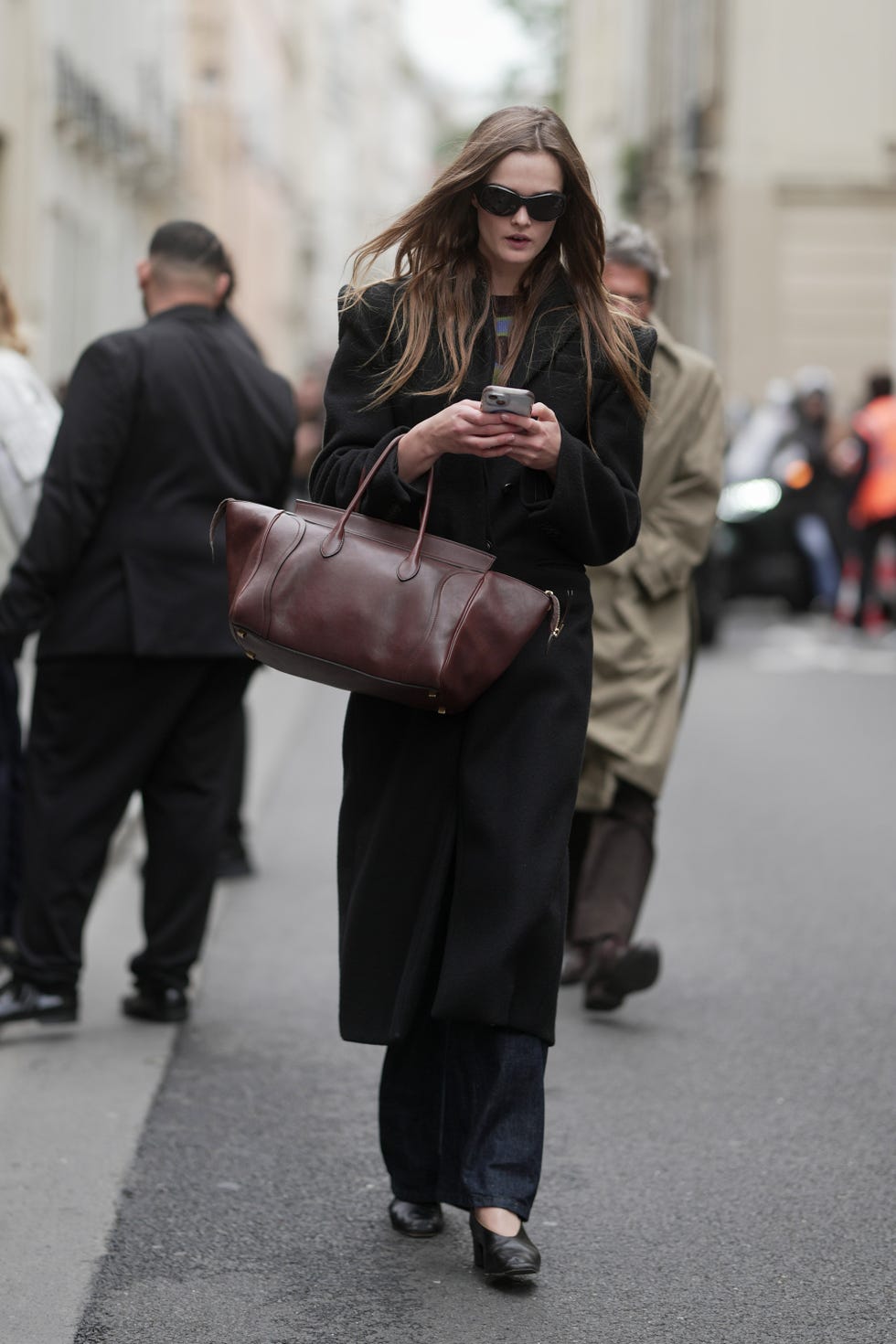 paris, france 06 octobre : lulu tenney porte de longs cheveux bruns lâches, un pardessus noir, un jean large bleu, des chaussures noires à bout pointu et un grand sac fourre-tout en cuir marron à l'extérieur de sacai pendant la collection printemps-été 2026 de vêtements pour femmes dans le cadre de la fashion week de paris le 06 octobre 2025 à paris, france. (photo de 305pics/getty images)