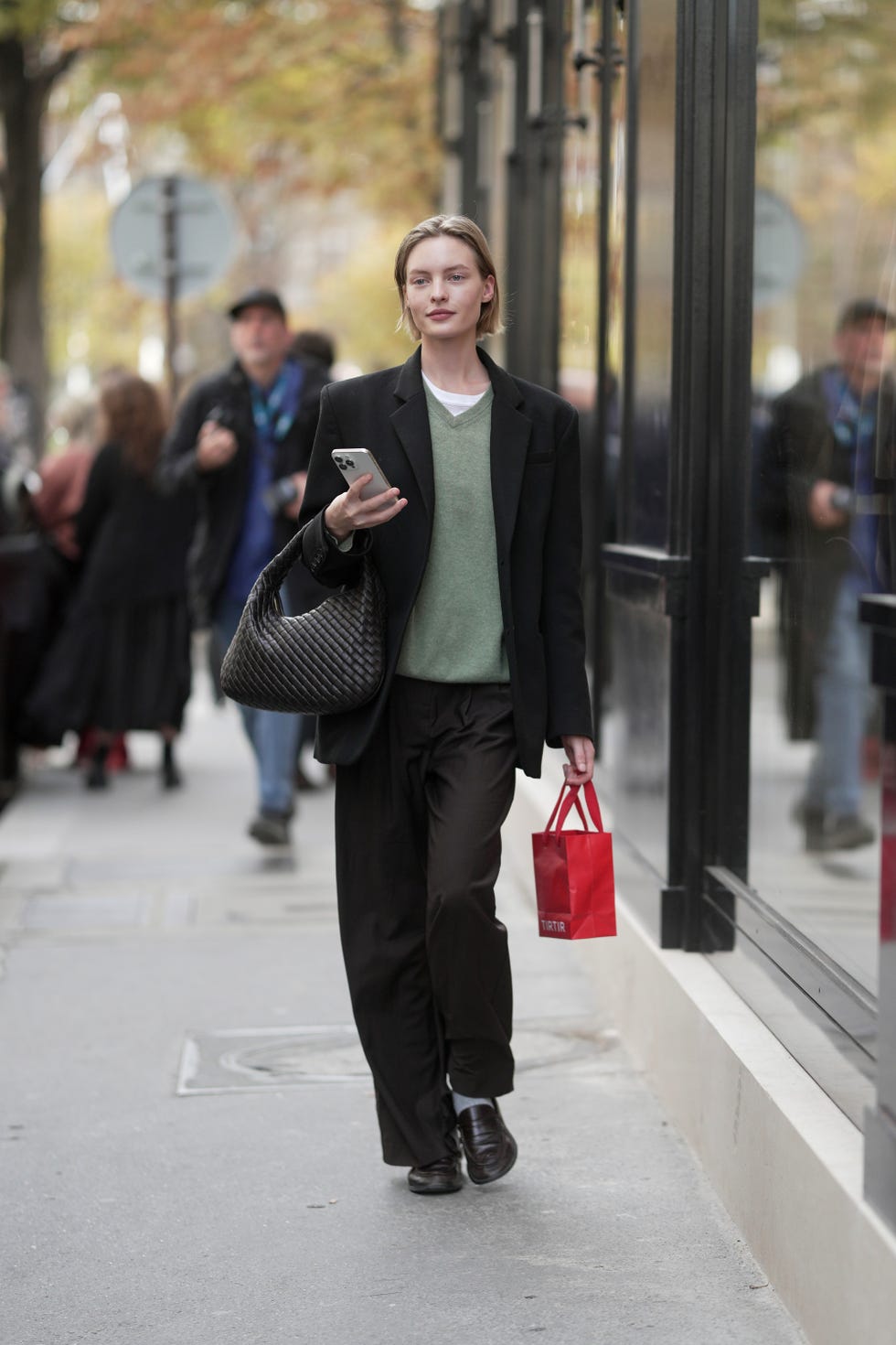 paris, france 02 octobre : maya vozhdaeva porte un t-shirt blanc à col rond superposé à un pull vert sauge, un blazer noir sur mesure, un pantalon large marron, des chaussures marron, portant un grand sac fourre-tout noir tissé à l'extérieur de carven pendant le printemps-été 2026 de vêtements pour femmes dans le cadre de la fashion week de paris le 02 octobre 2025 à paris, france. (photo de 305pics/getty images)