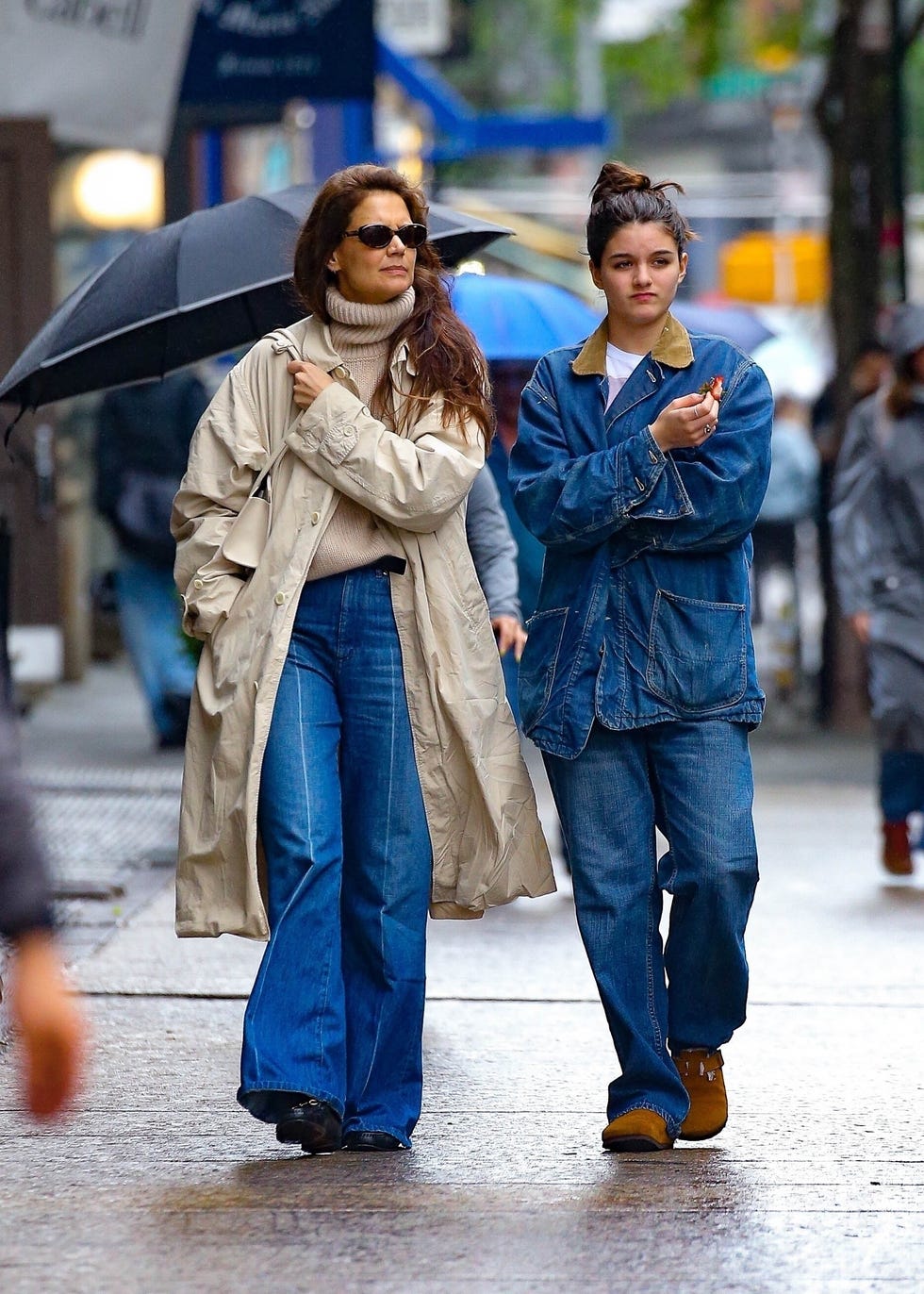 deux individus marchant dans une rue de la ville sous un parapluie