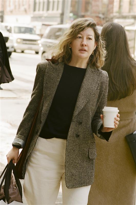 femme marchant dans la rue tenant une tasse de café et un sac à provisions
