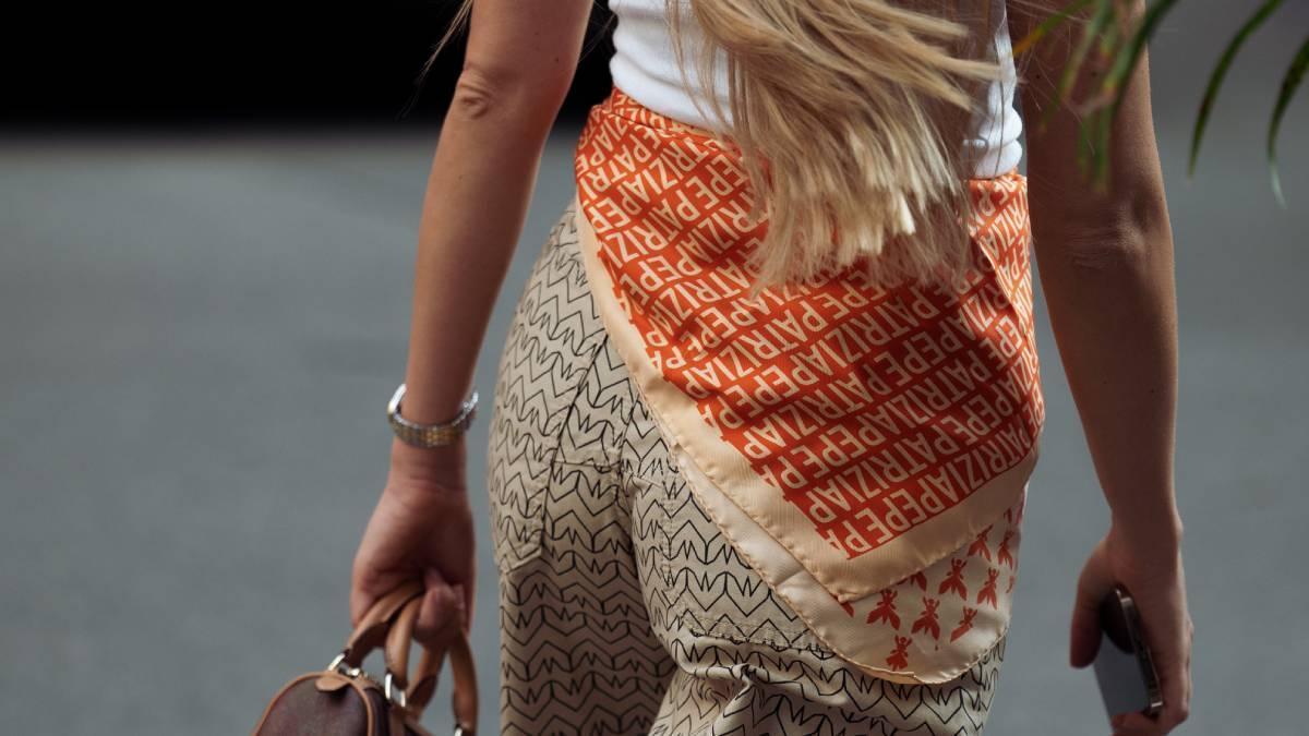 Esta primavera-verano 2026 los pañuelos se llevan anudados a la cintura sobre el pantalón