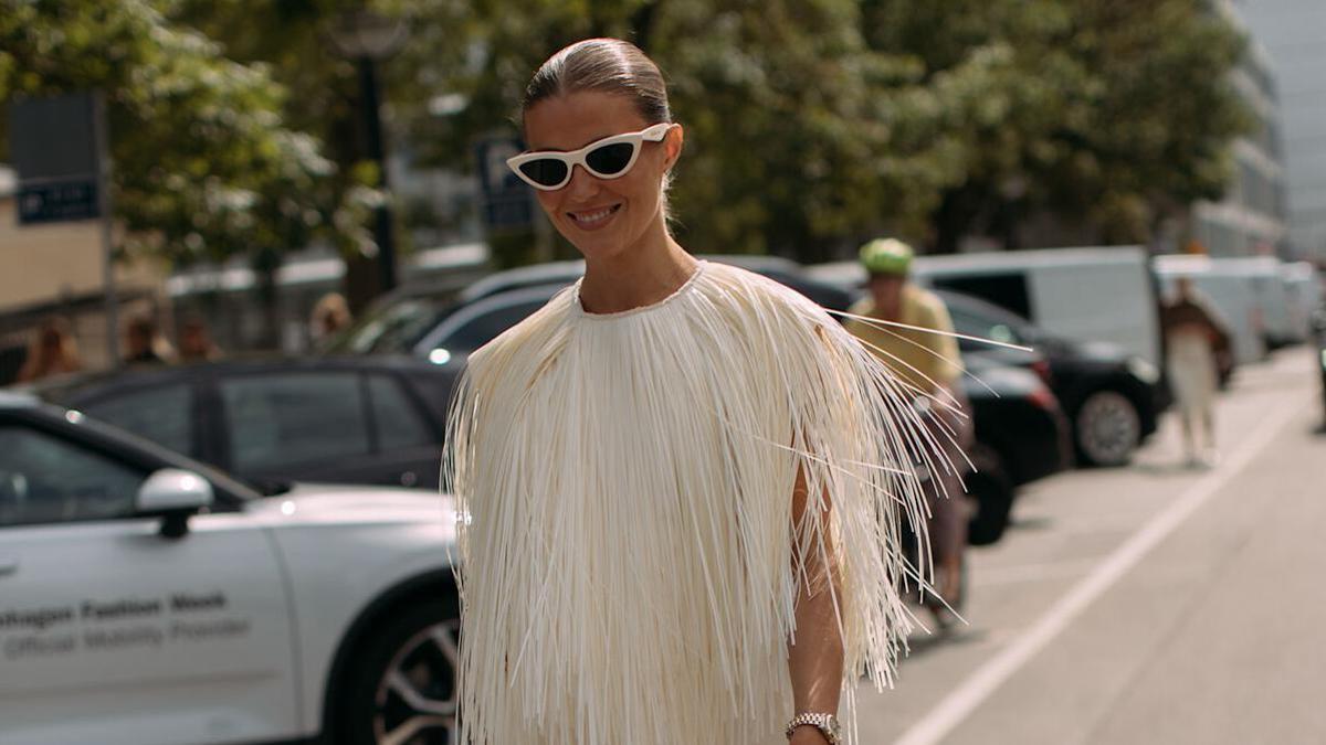 Look de street style con un vestido blanco con flecos