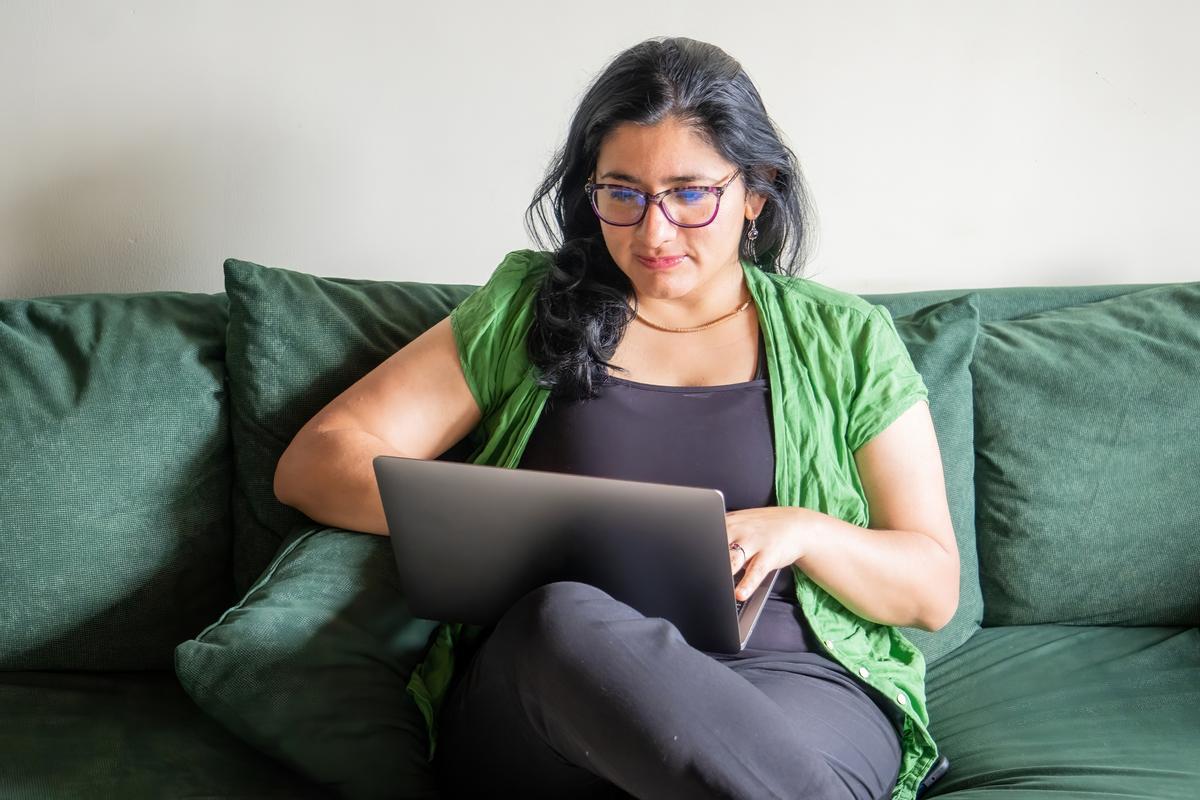 Femme avec ordinateur portable sur canapé