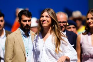 Infanta Sofía en blanc immaculé pour son événement sportif avec la Formule 1 : chemisier texturé à manches mi-longues, pochette en raphia et ceinture chocolat