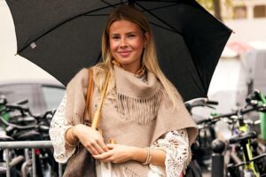 Les filles chics du Nord ont de nouvelles baskets préférées pour les jours de pluie : ce sont les Converse gris plomb résistantes à l'eau qui se combinent avec un imperméable et un jean pattes d'éléphant cet automne/hiver | BASKETS CONVERSE